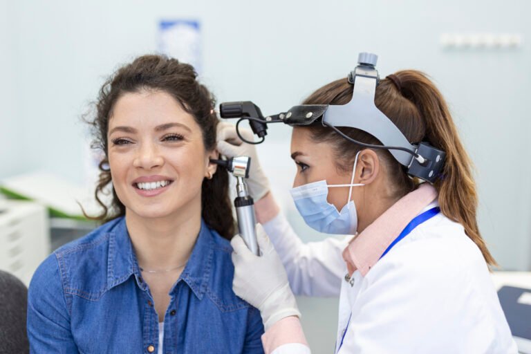 hearing exam. otolaryngologist doctor checking woman's ear using otoscope or auriscope at medical clinic.