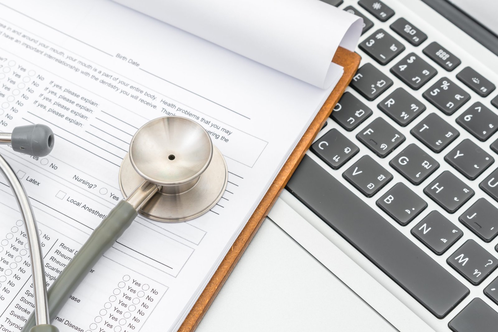 stethoscope and prescription on laptop